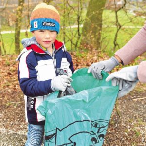 Ein Junge und eine Frau sammeln Müll.