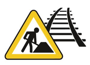 Baustellen-Warnschild vor schemenhafter Zeichnung von Schienen.
